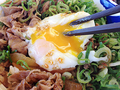 旨辛ネギたま牛めしの温泉玉子を潰して混ぜる